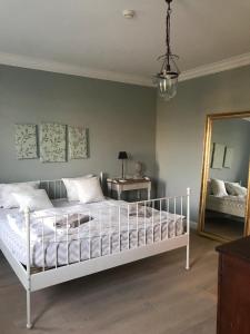 Schlafzimmer mit einem weißen Bett und einem Spiegel in der Unterkunft Gols in Gols