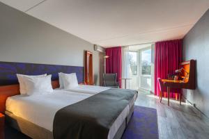 a hotel room with a large bed and a window at Amrâth Berghotel Amersfoort, BW Signature Collection in Amersfoort