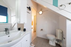 La salle de bains blanche est pourvue de toilettes et d'un lavabo. dans l'établissement Bandol 184 - Kustpark Village Scaldia, à Hoofdplaat