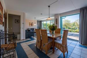a dining room and living room with a table and chairs at Bandol 184 - Kustpark Village Scaldia in Hoofdplaat