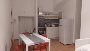 Una cocina con una mesa blanca y sillas rojas. en Appartament la Maison Petit Napoli, en Nápoles