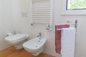 biała łazienka z toaletą i umywalką w obiekcie Lakefront Contemporary - by My Home In Como w mieście Cadenabbia