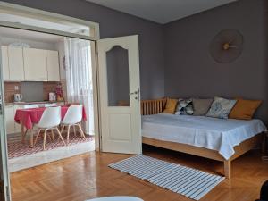 a bedroom with a bed and a kitchen with a table at Stan na dan "Irina" Banja Luka in Banja Luka