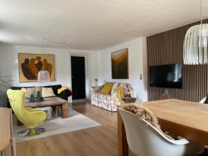 uma sala de estar com uma mesa e um sofá em Cozy Nature House em Svendborg