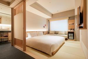 a bedroom with a large white bed and a couch at Agora Kyoto Karasuma in Kyoto