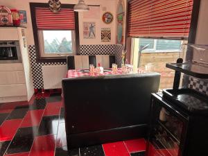 cocina con mesa y suelo rojo y negro en Gleninver Guest House en Inverness