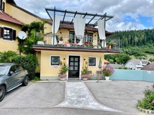 una casa con un balcón con un coche aparcado delante en Wohlfühlappartement im Zentrum Spittals en Spittal an der Drau