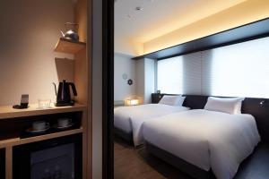 a hotel room with two beds and a fireplace at Agora Kyoto Shijo in Kyoto