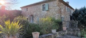 an old stone house in the middle of a garden at Le domaine du Moulin de Cors in La Roque-sur-Cèze