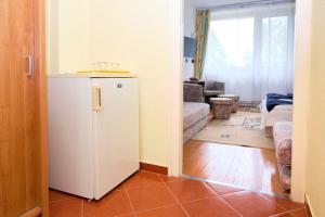 a kitchen with a refrigerator and a living room at Retro Lido - Vonyarcvashegy in Vonyarcvashegy