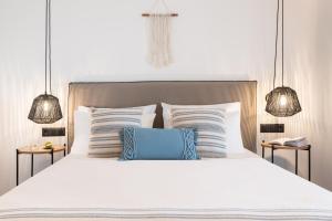 a bedroom with a white bed with two lamps at Eden Kythira in Dhiakofti