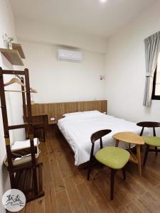 1 dormitorio con 1 cama, 2 sillas y mesa en 默森民宿, en Huxi
