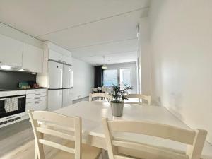 cocina blanca con mesa blanca y sillas en Easy Stay Room near Airport, en Vantaa