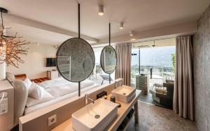 a bathroom with two sinks and a living room at Hotel Mitterplatt (Schenna Resort) in Schenna