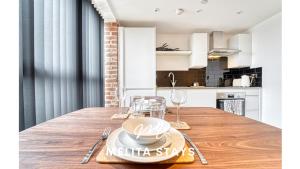 a kitchen and dining room with a wooden table at Modern 1 bedroom apartment in Burton upon Trent