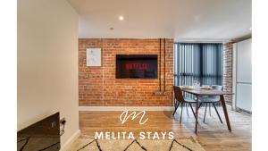 a dining room with a brick wall and a table at Modern 1 bedroom apartment in Burton upon Trent