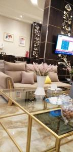 امارلس للشقق الفندقية في خميس مشيط: غرفة معيشة مع أريكة وطاولة زجاجية