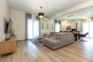 een woonkamer met een bank en een tafel bij Villa Relax with sauna & jacuzzi &gym in Gornji Zemunik
