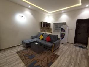 امارلس للشقق الفندقية في خميس مشيط: غرفة معيشة مع أريكة وثلاجة