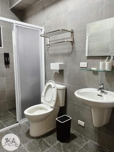 a bathroom with a toilet and a sink at 默森民宿 in Huxi