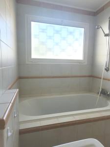 a bathroom with a bath tub and a window at La Suite de Saint-Jean-Cap-Ferrat, vue mer et accès mer in Saint-Jean-Cap-Ferrat