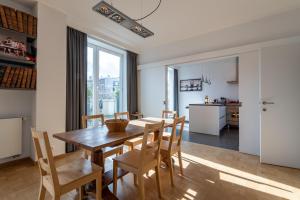 een keuken en eetkamer met een houten tafel en stoelen bij Woods Terrace residence in Brussel