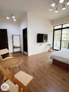 Schlafzimmer mit einem Bett, einem Tisch und einem TV in der Unterkunft 默森民宿 in Huxi