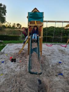 Ein kleines Kind sitzt auf einer Schaukel in der Unterkunft Parkhoeve Glamping in Ham