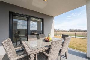 a dining room with a glass table and chairs at Appartements Thermen-Golfresort Pannonia in Zsira