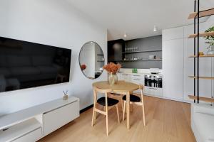 eine weiße Küche mit einem Tisch und einem Spiegel in der Unterkunft Luxury Aura 40 - 2 by Grand Apartments in Danzig