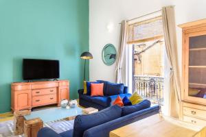 sala de estar con sofá azul y TV en Sliema Balluta 2 b/r apartment en Sliema