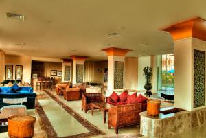 ein Wohnzimmer mit Sofas, Stühlen und Tischen in der Unterkunft Aurora Bay Resort Marsa Alam in Marsa Alam City