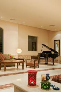 een woonkamer met een piano en een bank bij Aurora Bay Resort Marsa Alam in Marsa Alam