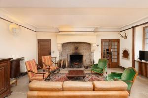 sala de estar con sofá y chimenea en Château pour se retrouver, en Larochemillay