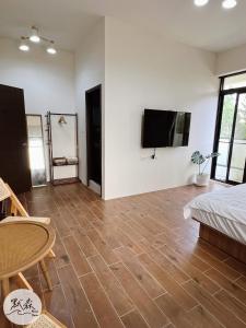 a living room with a flat screen tv on the wall at 默森民宿 in Huxi +26 photos