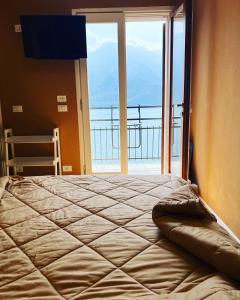 a bed in a room with a large window at Villa Castello only room in Limone sul Garda