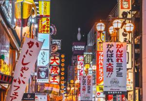 uma rua da cidade com muitos sinais e luzes em Agora Place Osaka Namba em Osaka