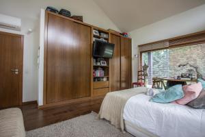 a bedroom with a bed and a cabinet with a television at Arrabida's Paradise in Azeitao