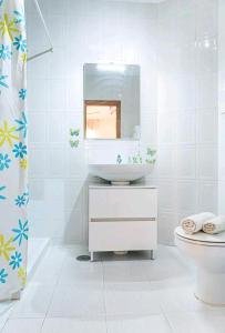 a bathroom with a sink and a mirror and a toilet at Los Duendes in Almería