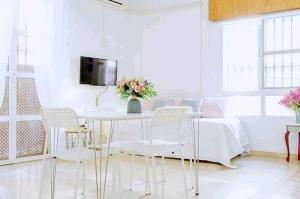 a white dining room with a table and chairs at Los Duendes in Almería