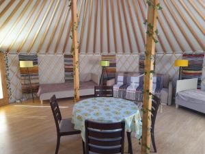 a room with a table and chairs and a tent at Szent Márton Jurtaszállás Zalakaros közelében in Nagyrécse