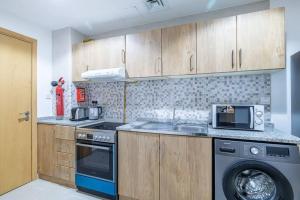 a kitchen with a washing machine and a washer at Cozy spacious Luxury Studio in Dubai