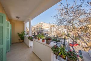 a balcony with potted plants and a view of a city at Frises Corfu Town Apartment in Ágios Rókkos
