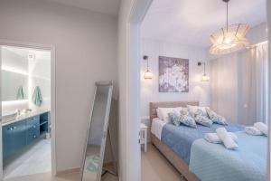 a bedroom with a blue bed and a mirror at Frises Corfu Town Apartment in Ágios Rókkos