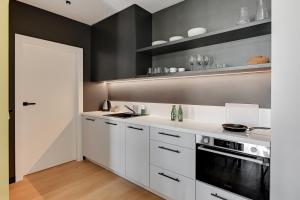 cocina con armarios blancos y fogones en Luxury Aura 40 - 4 by Grand Apartments en Gdansk