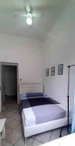 a bed in a bedroom with a ceiling fan at Mondello Home "46 passi" in Palermo