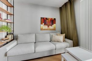una sala de estar con un sofá blanco en una habitación en Luxury Aura 40 - 4 by Grand Apartments en Gdansk