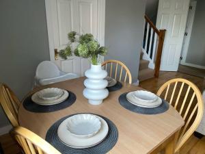 a table with plates and a vase on top of it at Villa in Youghal - Carleton Village in Youghal
