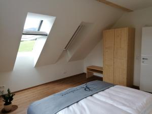 1 dormitorio en el ático con cama y ventana en Riesenbauer, en Zeutschach