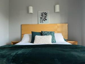 sypialnia z dużym łóżkiem z zieloną pościelą i poduszkami w obiekcie Villa in Youghal - Carleton Village w mieście Youghal
